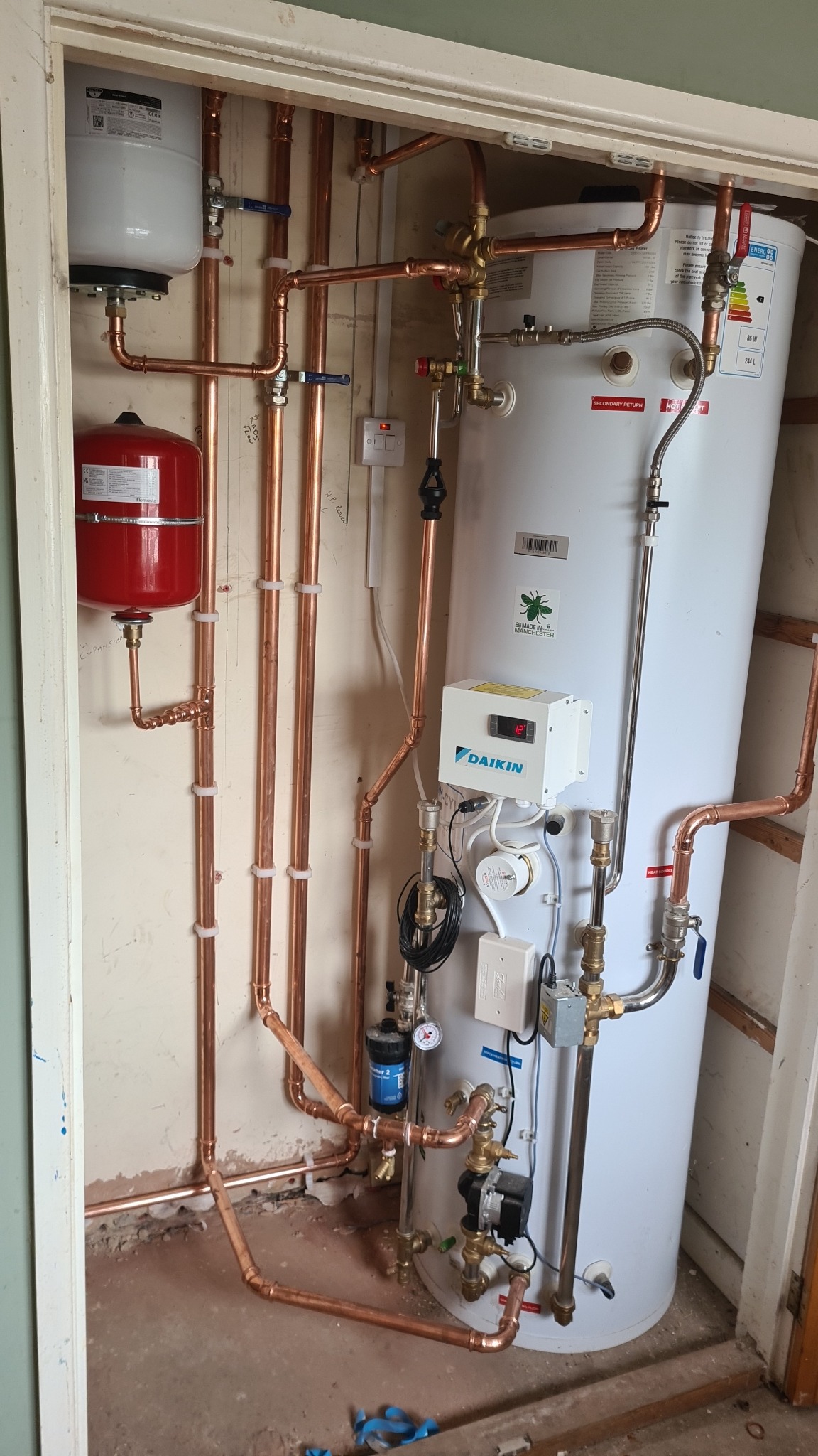 Hot water cylinder and controls inside cupboard
